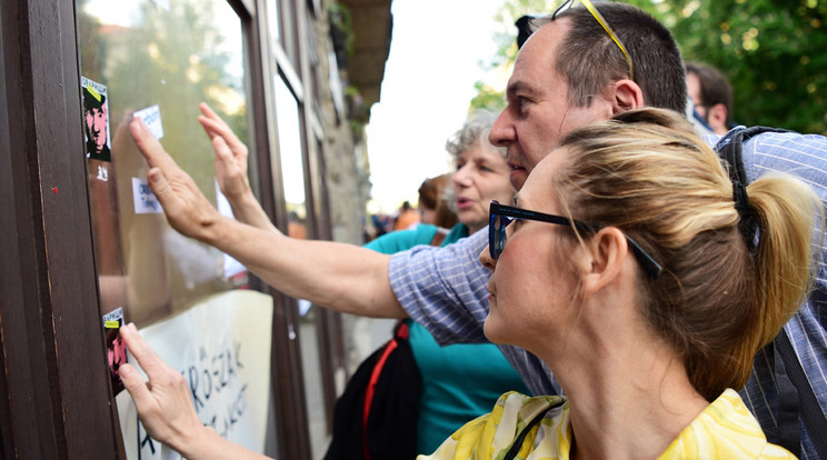 Az újságíró mellett tüntetők matricákkal borítják be a Fidesz újbudai irodáját /Fotó: MTI - Balogh Zoltán
