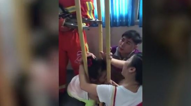 A kínai kislány feje beszorult a két kapaszkodórúd közzé