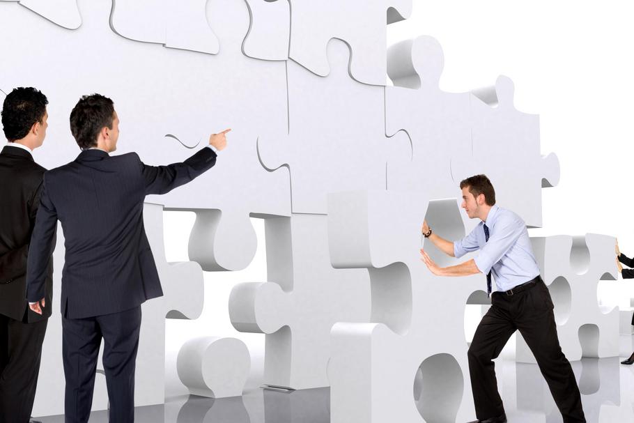 business teamwork - business men making a puzzle