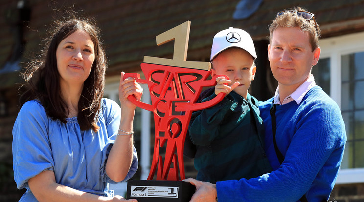 A beteg kisfiú és szülei Lewis Hamilton trófeáját tartják /Fotó: Northfoto