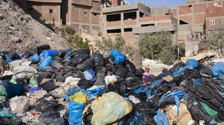 Zabbál asszonyok válogatják át a szemetet a hasznos, újrahasznosítható tárgyak után kutatva Moqqatam főbejárata előtt. Moqqatam egy külváros Kairó szélén, ahol a zabbálok élnek, akikről azt mondják, hogy a világ legnagyobb hulladék-újrahasznosítói. A zabbálok, ami egyszerűen annyit jelent, hogy "a szemétgyűjtők", naponta mintegy 4000 tonna kairói hulladékot szednek össze. Amerikai kutatók kimutatták, hogy a zabbálok ennek a szemétnek 85%-át hasznosítják újra: ez magasabb arány, mint bárhol máshol a világon. A férfiak két műszakban dolgoznak, reggel 4 óra körül indulnak, majd 9 óra körül ismét. A szemetet visszaviszik Moqqatamba, ahol az asszonyok ülnek és válogatnak. A szerves hulladékot megetetik a jószágokkal (a zabbálok eredetileg sertéspásztorok), a többit pedig újrahasznosításra szelektálják. A népcsoport jövője bizonytalan: ha a kairói hatóságok a maguk útját járják, ez a mintegy 25 000 kopt keresztényből álló közösség, amely egy muszlim országban él, eltűnik, és vele együtt egyedi életmódjuk is. / Fotó: Getty Images