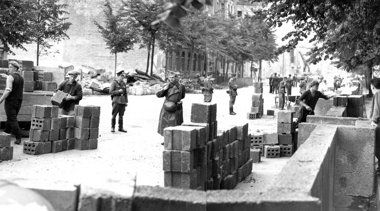 Munkások építik a berlini falat, fegyveres őrök szigorú felügyelete alatt /Fotó: Getty Images