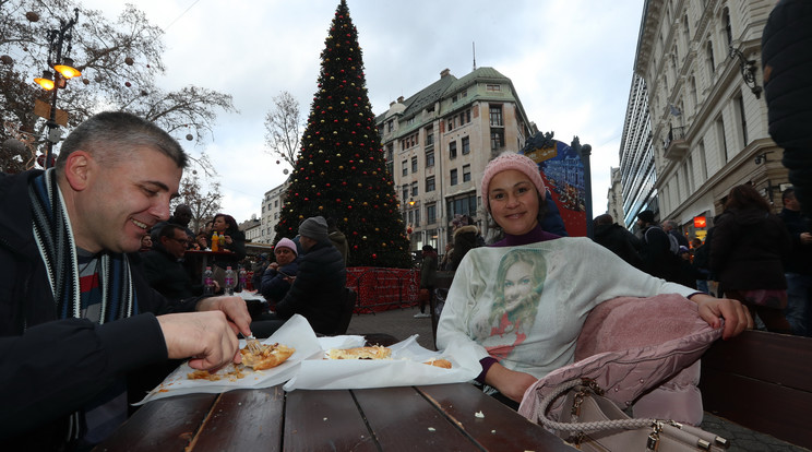 Ez a bolgár házaspár a Vörösmarty téren nemcsak a lángosnak örült, hanem annak is, hogy egy szál pulóver is elegendő volt a napsütötte teraszon, amíg elfogyasztották a csemegét /Fotó: Isza Ferenc