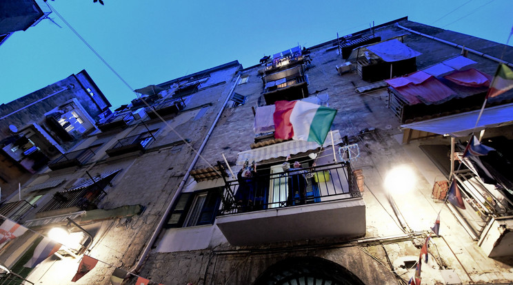 Lakásuk erkélyén énekelnek és zenélnek olasz fiatalok Nápolyban 2020. március 13-án. Olaszország több településén is szerveztek egy villámcsődületet (flashmobot), hogy a közösségi éneklés által az emberek könnyebben el tudják viselni a koronavírus-járvány miatt bevezetett korlátozásokat. Giuseppe Conte olasz miniszterelnök bejelentette, hogy az éttermeket, kávézókat és a kiskereskedelmi egységeket is bezárják az országban. / Fotó: .MTI/EPA/ANSA/Ciro Fusco