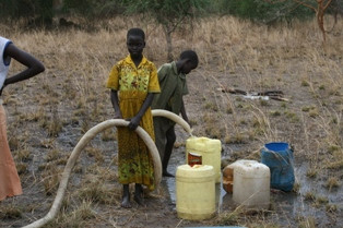 Dzieci pobierają wodę ze studni wybudowanej przez PAH