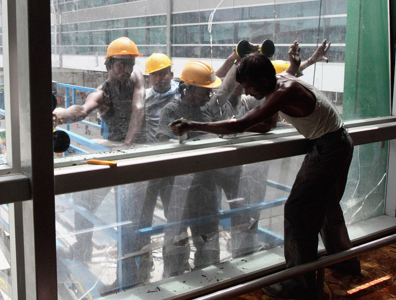Robotnicy instalują okna w Terminalu 3 będącym częścią Indira Gandhi International Airport