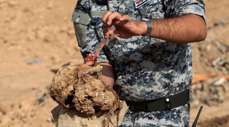 Iraki katona koponyát tart a kezében / Fotó: AFP