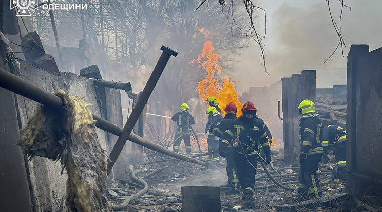 Az ukrán állami sürgősségi szolgálat felvételén tűzoltók fékezik meg a lángokat a kettős orosz rakétatámadásban megrongálódott lakóépület romjai között Odesszában / Fotó: MTI/EPA
