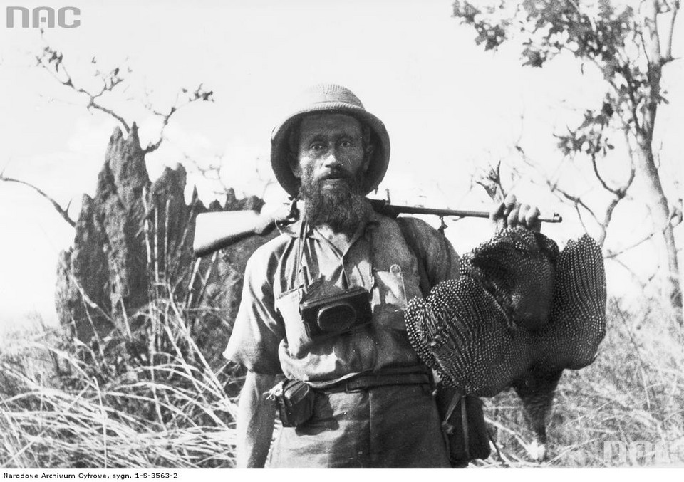 Kazimierz Nowak ze strzelbą na ramieniu i upolowanym ptakiem. Na szyi ma zawieszony aparat fotograficzny - rok 1934, Sudan