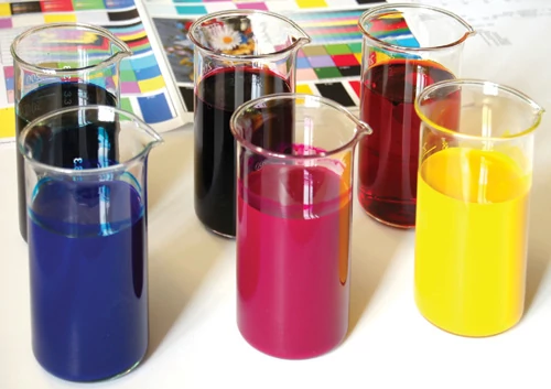 Tusze pigmentowe (na zdjęciu w pojemnikach stojących z przodu) są nieprzezroczyste  i mają bardziej intensywne kolory od atramentów rozpuszczalnikowych (z tyłu)