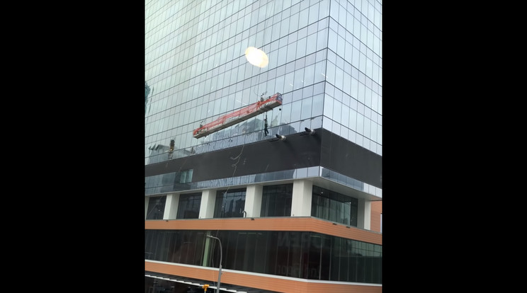 Az egyik ablakmosó le is zuhant az állványról, a biztosító kötél fogta meg / Fotó: YouTube