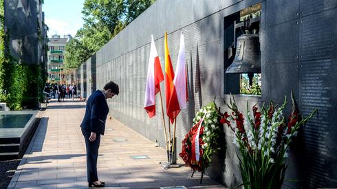 Premier Beata Szydło składa kwiaty przed dzwonem 