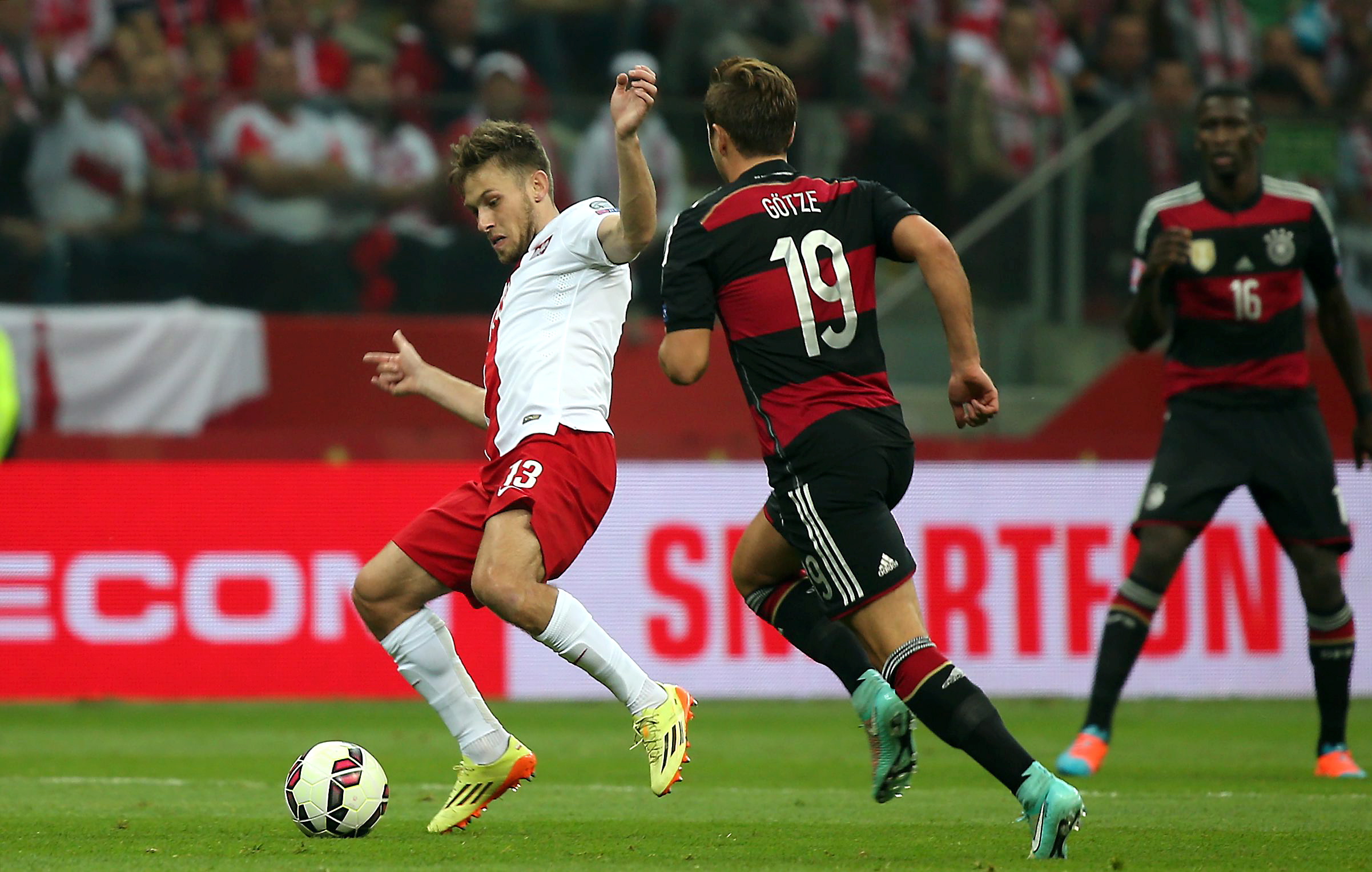 Polak Maciej Rybus (L) walczy o piłkę z Niemcem Mario Goetze (P) podczas meczu eliminacyjnego piłkarskich mistrzostw Europy w Warszawie