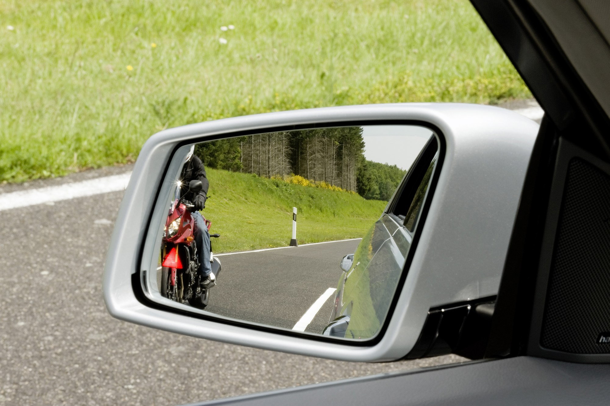 Водитель смотрит в зеркало. Боковые зеркала. Слепые зоны автомобиля в зеркала.