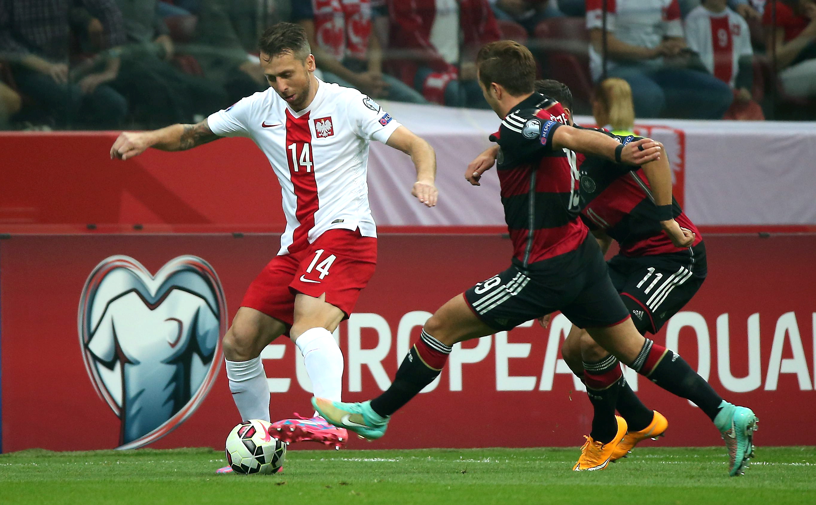 Polak Jakub Wawrzyniak (L) walczy o piłkę z Niemcem Mario Goetze (P) podczas meczu eliminacyjnego mistrzostw Europy w Warszawie