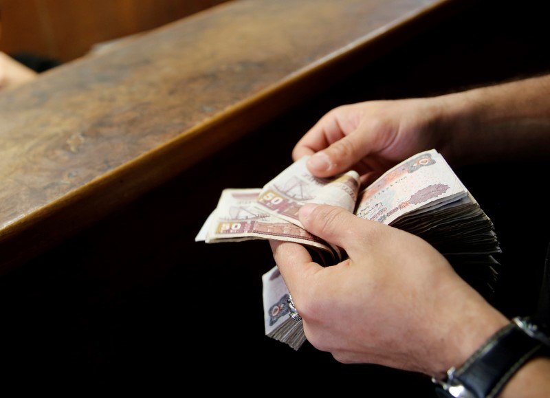 A customer counts his Egyptian 50 pound notes at an exchange office in downtown Cairo, Egypt, April 19, 2016. REUTERS/Amr Abdallah Dalsh