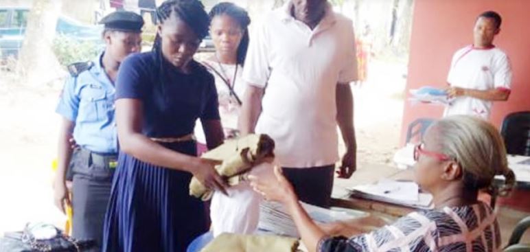 One of the two sacked female corps members returning her kits before being escorted out of the Ebonyi NYSC camp on Sunday, November 10, 2019.  (Punch)