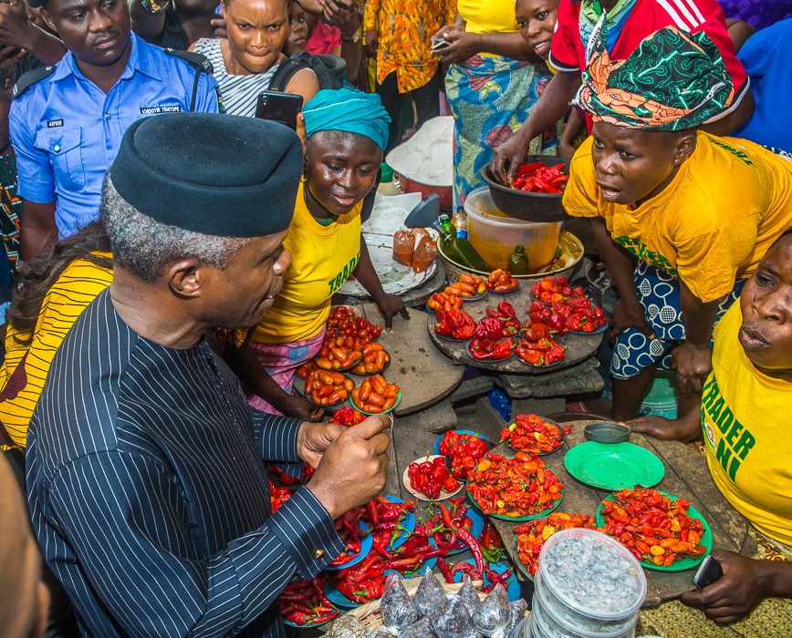 Vice-President Yemi Osinbajo sits with beneficiaries of the TraderMoni loan scheme in a market in Ibadan, Oyo State. [Premium Times]