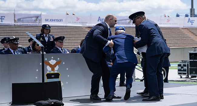 US President Joe Biden is helped up after falling during the graduation ceremony at the United States Air Force Academy, just north of Colorado Springs in El Paso County, Colorado, on June 1, 2023. (Photo by Brendan Smialowski/AFP)