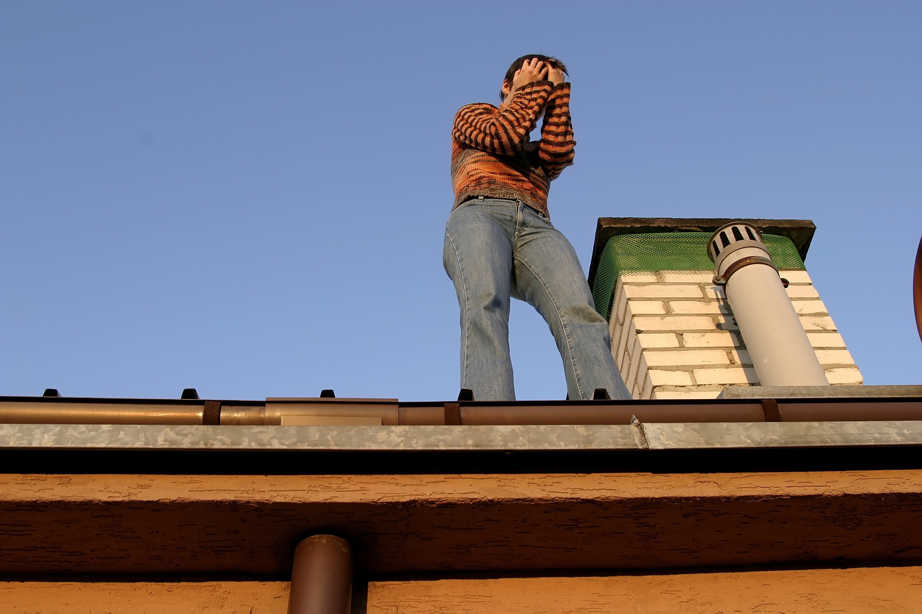 Крыша снизу. Человек на крыше. Человек сидит на крыше. Мужчина на крыше домика. Парень сидит на крыше.
