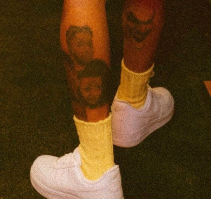 The tatoo shows the faces of three of his four sons