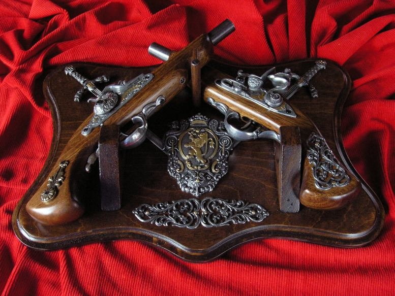 WŁOCHY DWA PISTOLETY NA DREWNIE Z HERBEM I MIECZAMI