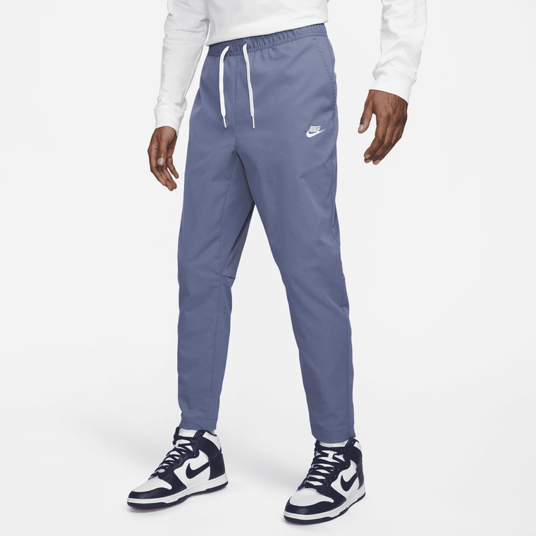 Męskie spodnie z tkaniny o zwężanym kroju Nike Club - Niebieski