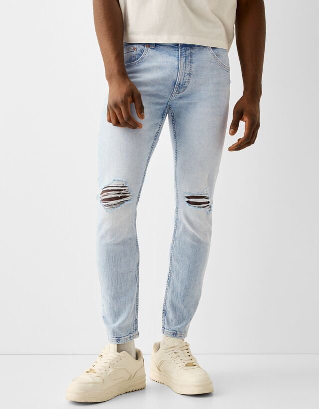 Bershka Jeansy O Kroju Skinny Z Efektem Podarcia Mężczyzna 36 Jasnoniebieski