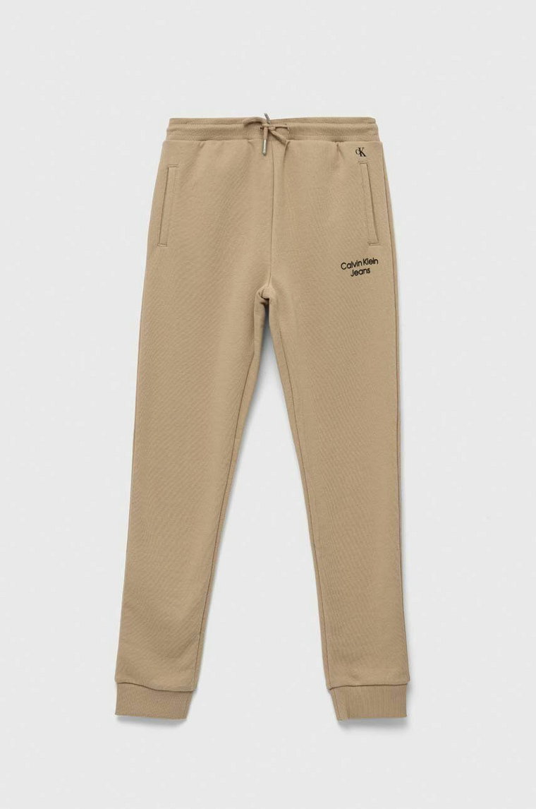 Calvin Klein Jeans spodnie dresowe dziecięce kolor beżowy gładkie