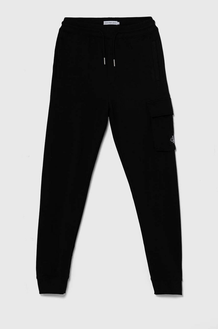 Calvin Klein Jeans spodnie dresowe bawełniane dziecięce BADGE CARGO RELAXED kolor czarny gładkie IB0IB02199