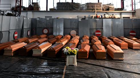 Widok przedstawia kilkadziesiąt trumien ze zmarłymi osobami, które są przechowywane w magazynie w Ponte San Pietro (Lombardia). Fot. Piero CRUCIATTI / AFP 
