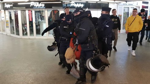 Policja wyciąga kontrmanifestantów przy stacji metra Centrum.