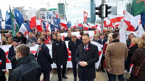 Uczestnicy Marszu Niepodległości, który przejdzie w piątek ulicami stolicy, gromadzą się wokół ronda Dmowskiego. Wielu z nich trzyma w rękach sztandary w barwach narodowych. Wzdłuż trasy przemarszu są duże siły policji.