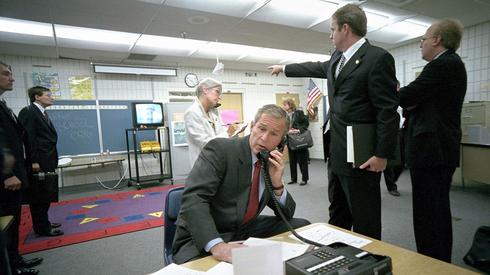 GettyImages-The White House Handout. George W. Bush rozmawia z członkami administracji znajdującymi się w Białym Domu. 