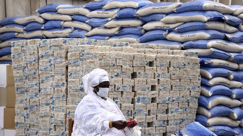 Przedstawiciel dzielnicy czeka, aż burmistrz Dakaru przekaże worki ryżowe i kostki mydła mieszkańcom 19 dzielnic stolicy Senegalu . fot. Seyllou/ AFP