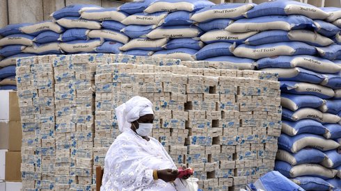 Przedstawiciel dzielnicy czeka, aż burmistrz Dakaru przekaże worki ryżowe i kostki mydła mieszkańcom 19 dzielnic stolicy Senegalu . fot. Seyllou/ AFP