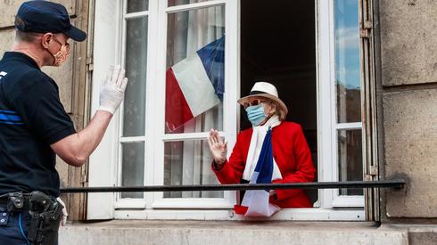 Policjant rozmawia ze starszą kobietą w Saint Mande. Dziś Francuzi świętowali na ulicach poluzowanie obostrzeń we Francji / fot. CHRISTOPHE PETIT TESSON, PAP