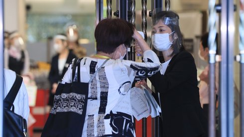 Galeria handlowa w japońskiej Osace. Klienci byli sprawdzani pod względem temperatury ciała i dezynfekowani przed wejściem do sklepu.  Fot. Kota Kawasaki / Yomiuri / AFP