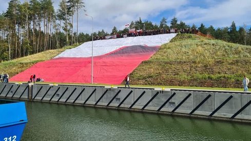 Na wzgórzu tuż przy kanale żeglugowym umieszczono ogromną flagę Polski