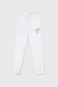 Spodnie i spodenki dla dziewczynek - Guess spodnie dresowe bawełniane dziecięce kolor biały z nadrukiem - miniaturka - grafika 1