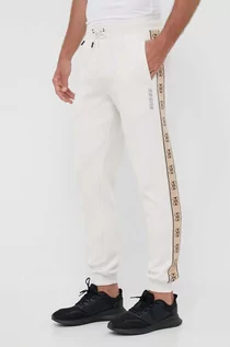 Spodnie męskie - Guess spodnie dresowe męskie kolor beżowy z nadrukiem - grafika 1