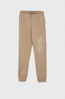 Spodnie damskie - Calvin Klein Jeans Jeans spodnie bawełniane dziecięce kolor beżowy z nadrukiem - grafika 1