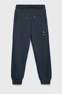 Spodnie i spodenki dla chłopców - Calvin Klein Jeans Jeans spodnie dresowe dziecięce kolor granatowy gładkie - grafika 1