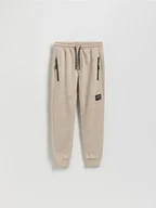 Spodnie i spodenki dla chłopców - Reserved - Bawełniane spodnie z kieszeniami - beżowy - miniaturka - grafika 1