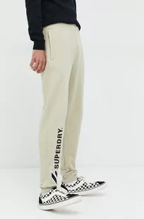 Superdry spodnie dresowe bawełniane męskie kolor beżowy z aplikacją - Spodnie męskie - miniaturka - grafika 1