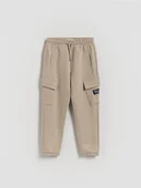 Spodnie i spodenki dla chłopców - Reserved - Spodnie jogger cargo - beżowy - miniaturka - grafika 1
