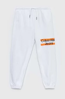 Spodnie i spodenki dla chłopców - Calvin Klein Jeans spodnie dresowe bawełniane dziecięce kolor biały z nadrukiem - grafika 1