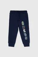 Spodnie i spodenki dla chłopców - Guess spodnie dresowe bawełniane dziecięce kolor granatowy z aplikacją - miniaturka - grafika 1