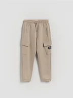 Spodnie i spodenki dla chłopców - Reserved - Spodnie jogger cargo - beżowy - miniaturka - grafika 1