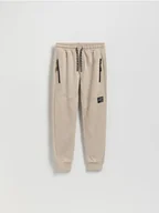 Spodnie i spodenki dla chłopców - Reserved - Bawełniane spodnie z kieszeniami - beżowy - miniaturka - grafika 1